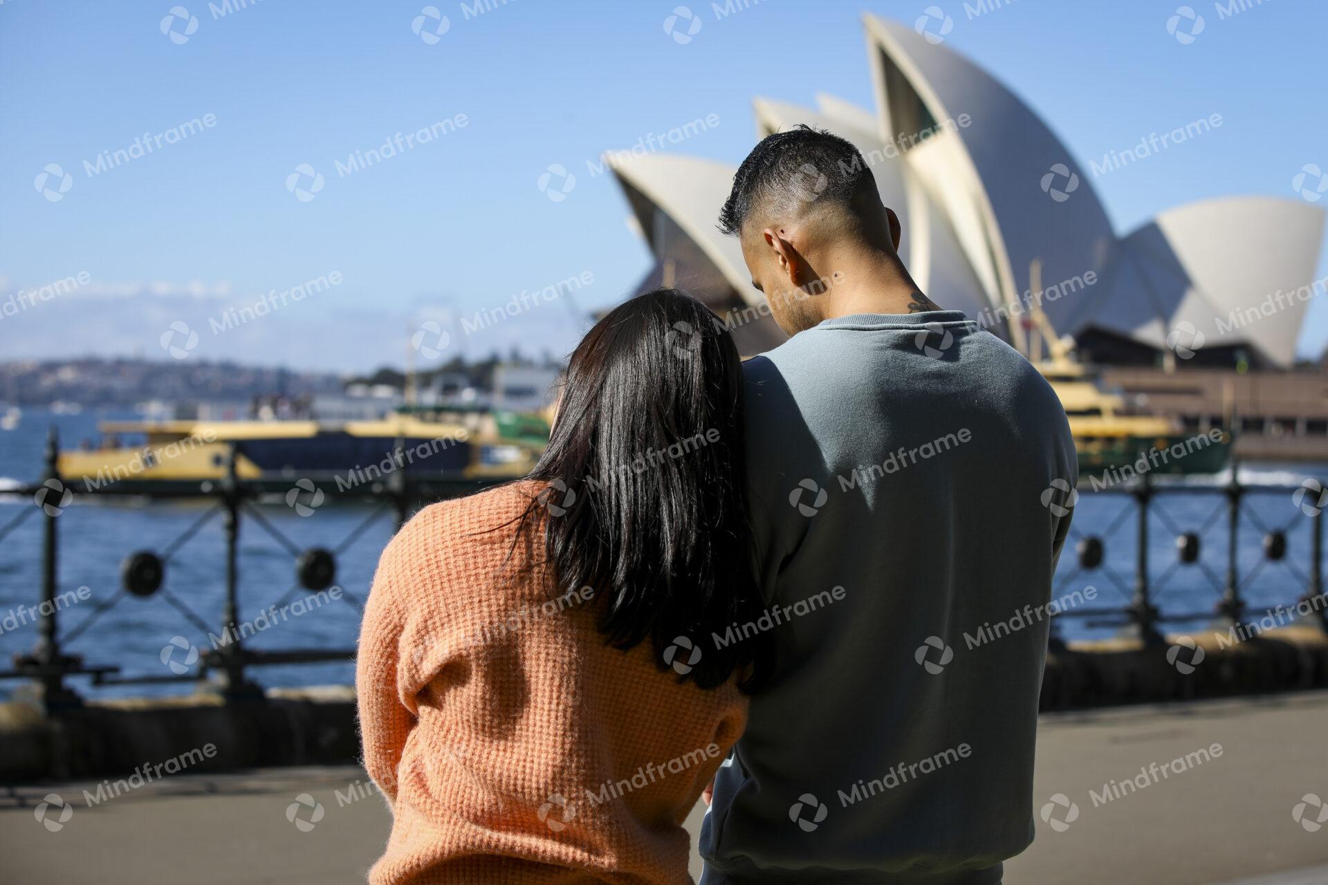 Two people standing together and looking at the water