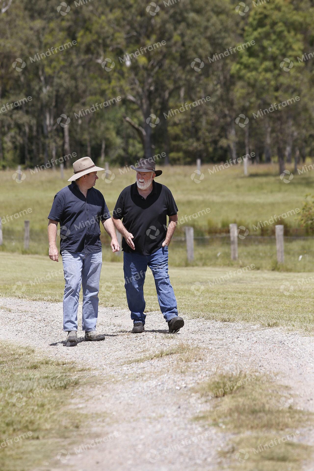 Two people at walking along a dirt road at a farm