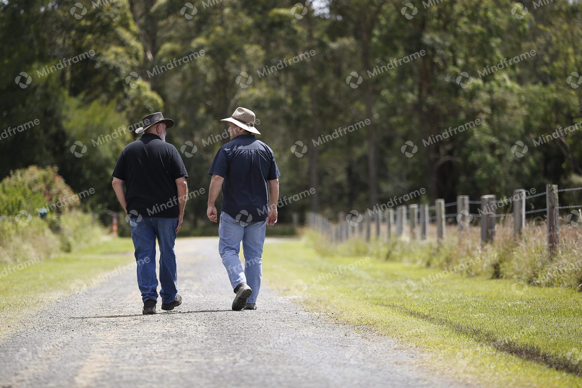 Two people at walking along a dirt road at a farm